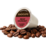 Ekocups compostable decaf hazelnut coffee pod surrounded by coffee beans on a white background